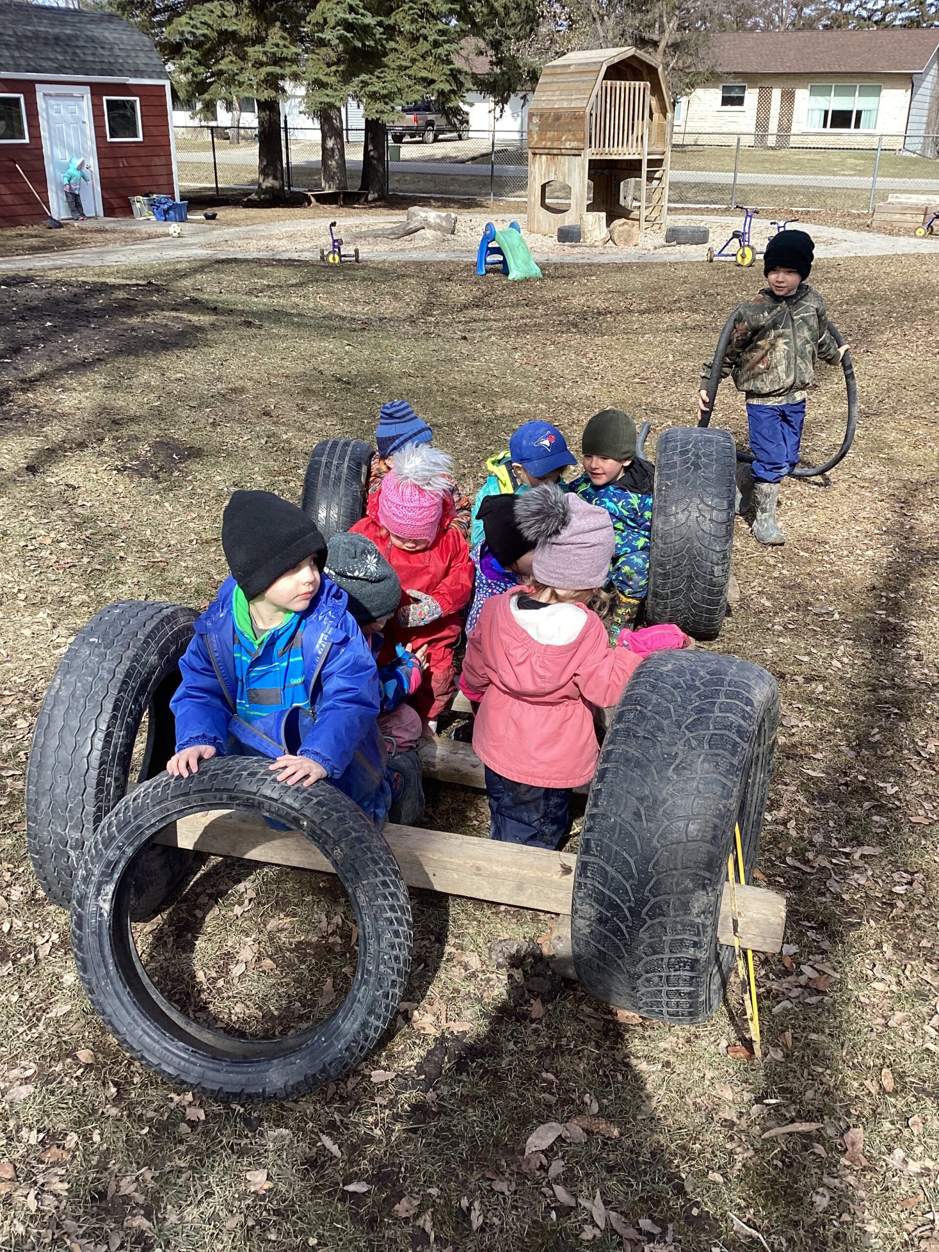 kids playing outside on tire structure