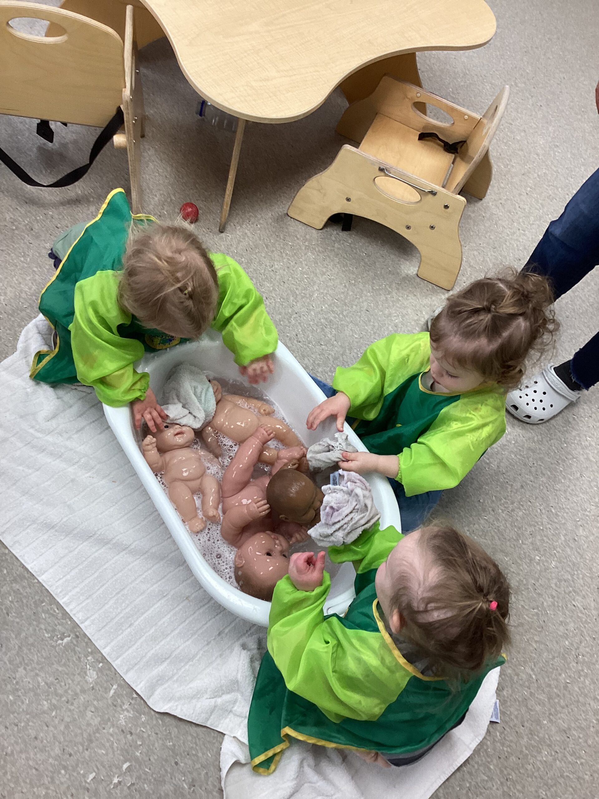 children washing toy babies in water