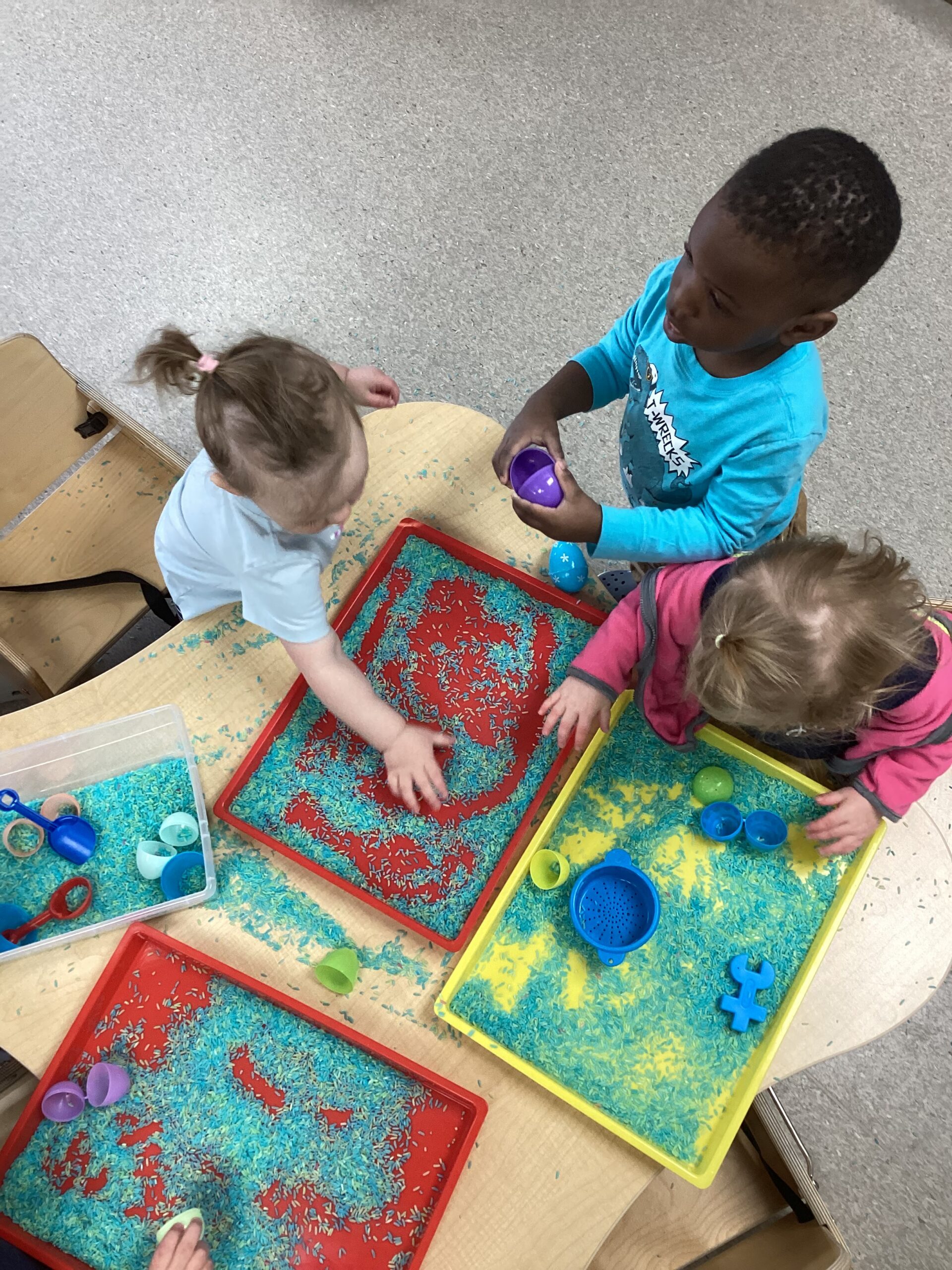 kids playing in small sand boxes inside